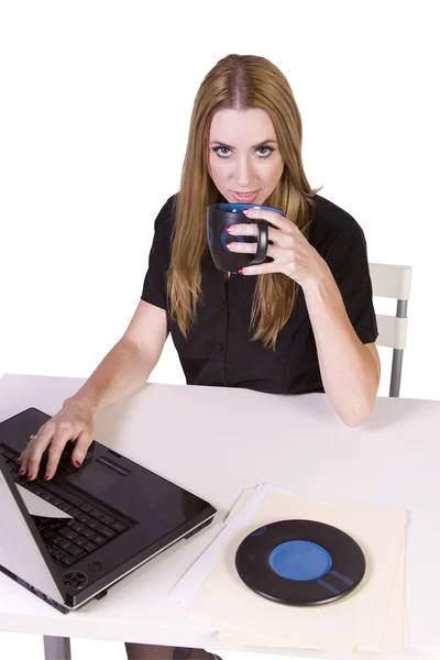 Empresaria trabajando en laptop con taza de café en su escritorio — Foto de Stock