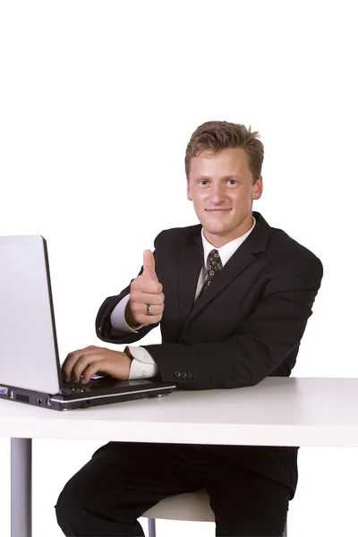 Homme d'affaires travaillant sur un ordinateur portable et gesticulant avec les pouces levés — Photo