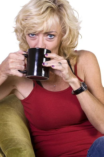 Женщина, сидящая на стуле и пьющая кофе — стоковое фото