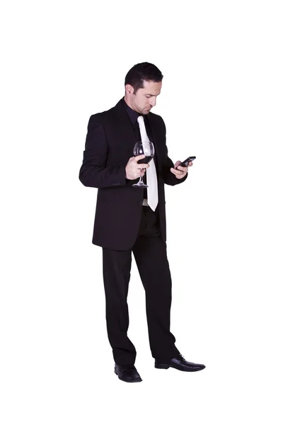 Businessman with a glass of drink texting — Stock Photo, Image