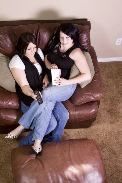 Két lány ül a kanapén, egy film — Stock Fotó