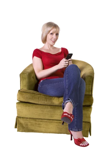 在家里的沙发上漂亮的女人发短信 — 图库照片