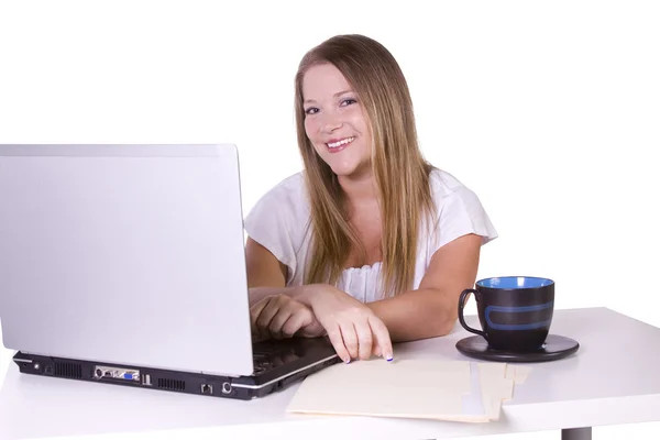 Zakenvrouw die op laptop met kop koffie op haar bureau werkt — Stockfoto