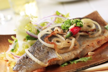 Pan-roasted trout fillet served with green salad clipart