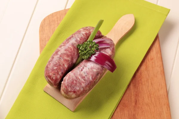 stock image Italian sausages and Spanish onion on cutting board
