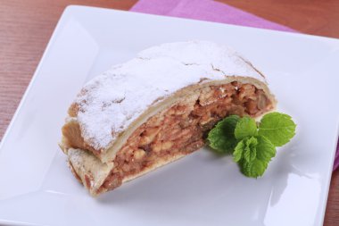 Slice of apple strudel powdered with icing sugar clipart