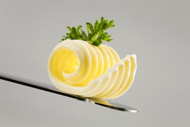 Closeup of a butter curl on a knife clipart