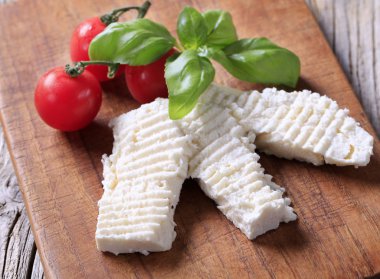 Slices of curd cheese on a cutting board clipart