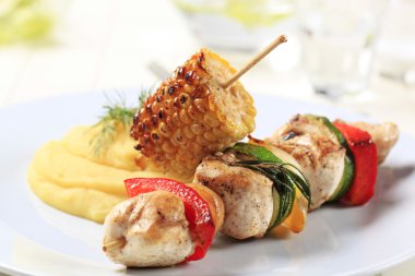 Chicken shish kebab and roasted corn cob with mashed potato clipart