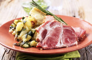 Gerookt varkensvlees met gemalen aardappelen en de gebakken knoflook