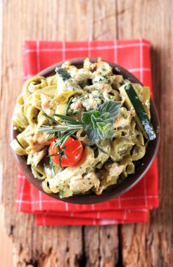 Spinach fettuccine with chicken meat, basil pesto and cream clipart