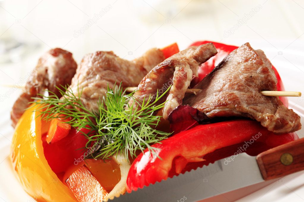 Roasted meat on skewer and baked vegetable