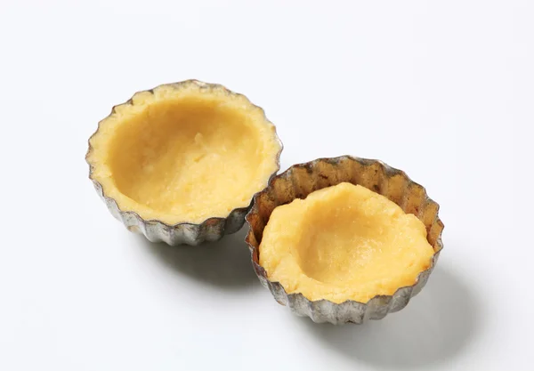 Raw dough in small tart pans — Stock Photo, Image