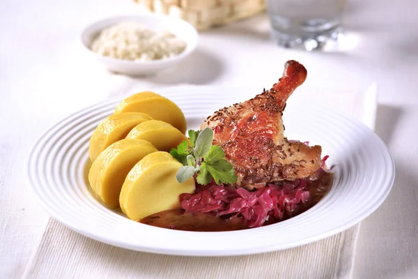 Жареная утка с красной капустой и картофельными пельменями — стоковое фото