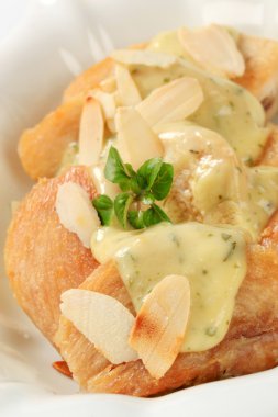 Roasted chicken with herb sauce and almonds clipart