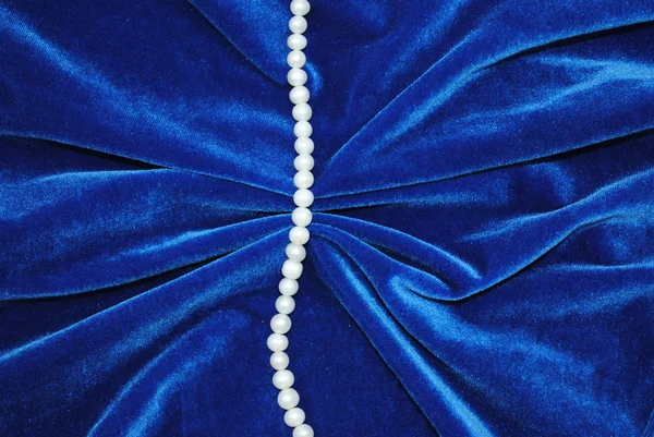 Pearl on turn blue velvet — Stock Photo, Image