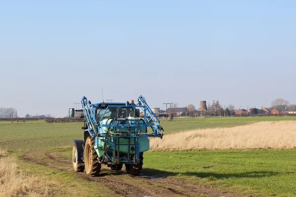 Kék traktorral vontatott permetező berendezés — Stock Fotó