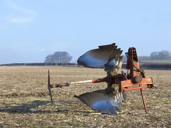 Red plow in a field — Stock Photo, Image