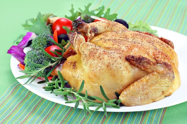 烤岩康沃尔母鸡包围迷迭香对盘花配蔬菜色拉 — 图库照片