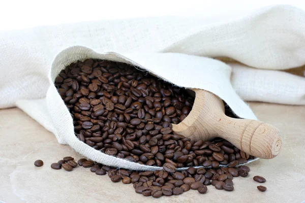 Coffee beans spilling from burlap sack. — Stock Photo, Image