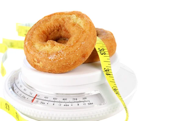Donuts en escala de alimentos con cinta métrica —  Fotos de Stock