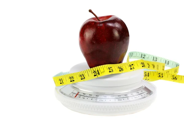 Maçã, fita métrica na escala de alimentos — Fotografia de Stock