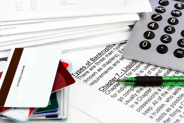Bankruptcy document with bills, credit cards, calculator and pen — Stock Photo, Image