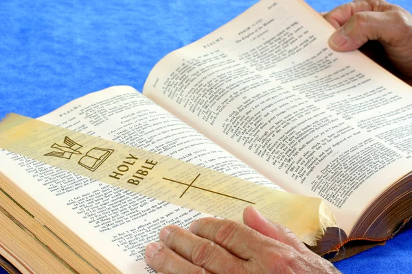 Bible ouverte avec les mains de l'homme en position de lecture . — Photo