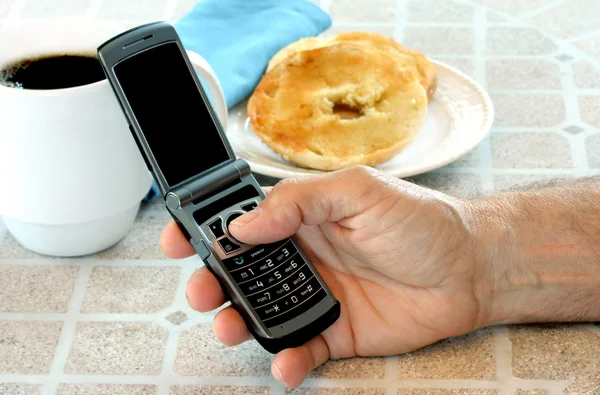 オープン携帯電話で朝食のテーブルで手をマンします。. — ストック写真