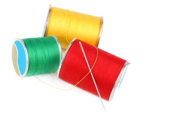 Three colorful spools of thread and needle on white — Stock Photo, Image