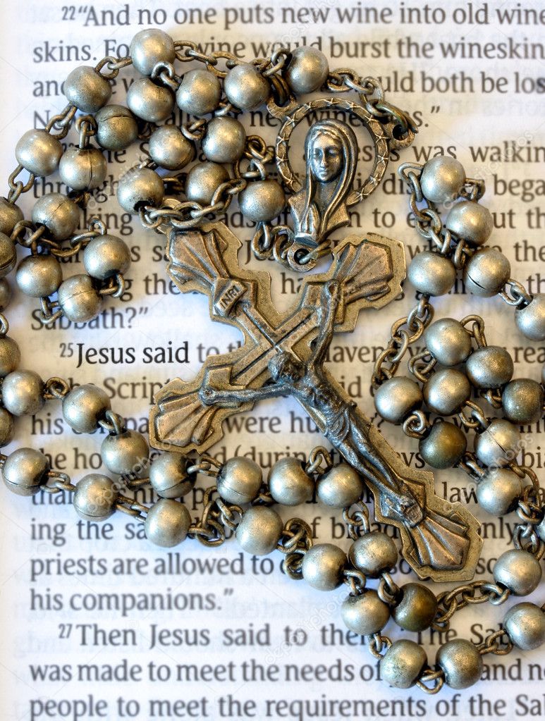 Vintage rosary beads on page of a bible.