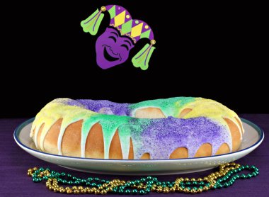 Kings Cake in Mardi Gras Setting clipart