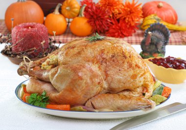 Whole roasted turkey in Thanksgiving setting. clipart