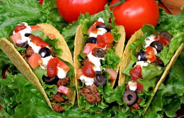 Läckra tacos i en bädd av gröna. — Stockfoto