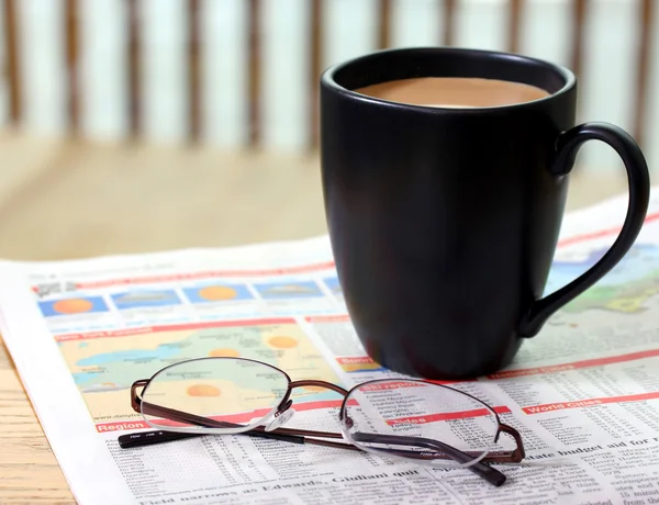 Hot coffee, a newspaper and glasses. — Stock Photo, Image