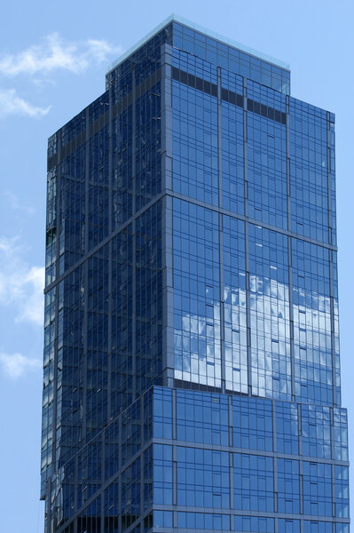 Reflection of a cloudy sky in glass wall of an office building