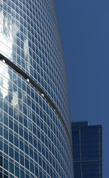 Отражение облачного неба в стеклянной стене офисного здания — стоковое фото