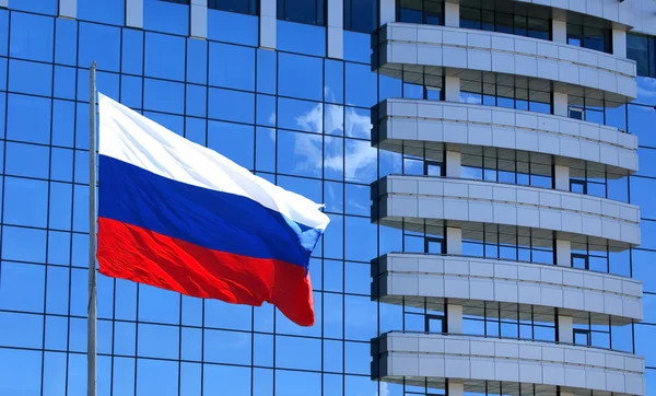 Ruské vlajky na pozadí windows kancelářská budova — Stock fotografie
