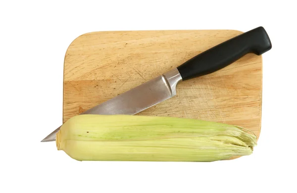 Натюрморт с натуральным кукурузным початком с ножом и доской. In isola — стоковое фото