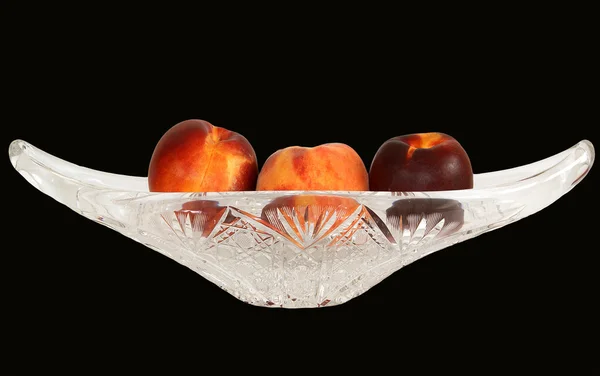 Duże, dojrzałe nektaryny w Kryształowy wazon do owoców na czarny — Zdjęcie stockowe