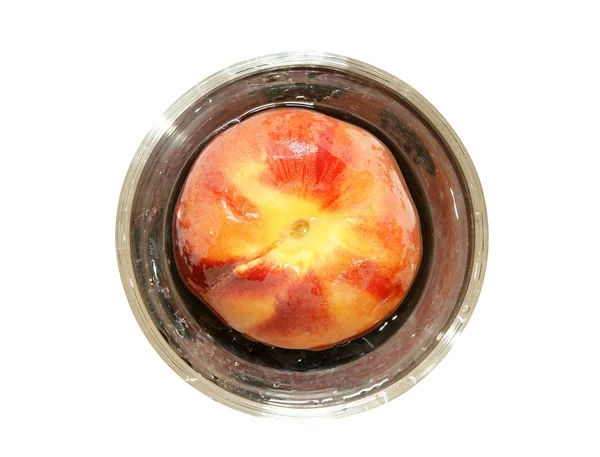 Durazno maduro grande en un jarrón de cristal, vista superior, aislado sobre fondo blanco — Foto de Stock
