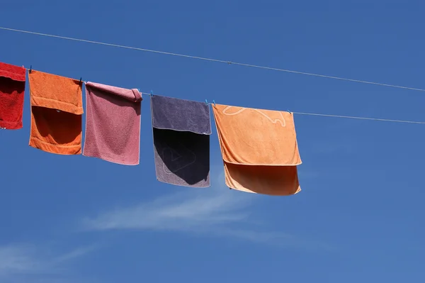 Multi-gekleurde handdoeken tegen de blauwe hemel — Stockfoto