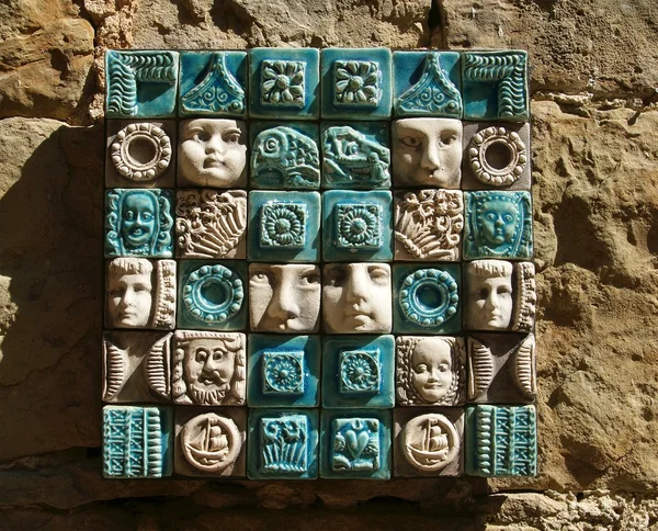Ceramic panels depicting 's heads, side light — Stock Photo, Image