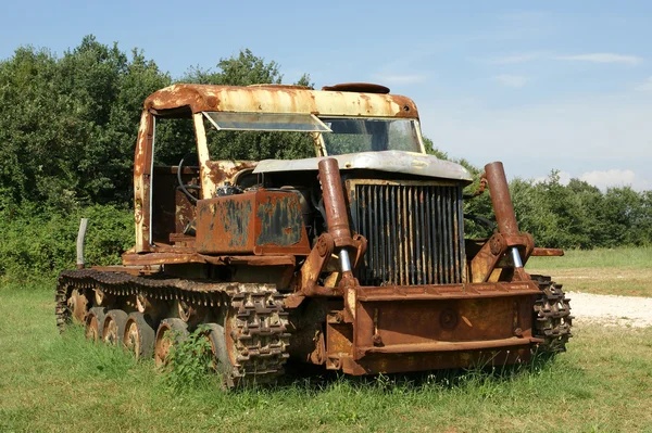 Старый ржавый трактор в летнем поле — стоковое фото