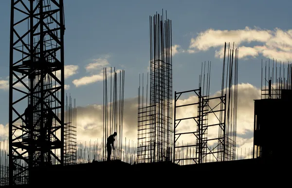 建設作業員 建設用機器および日没で建設中の建物の要素のシルエット ロイヤリティフリーのストック画像
