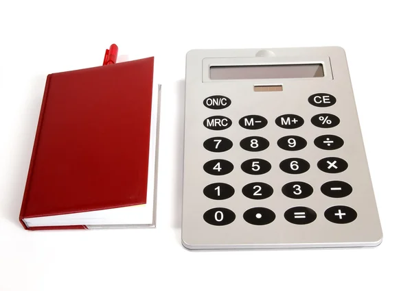 Gran calculadora y cuaderno rojo para notas diarias de referencia con un bolígrafo en un — Foto de Stock