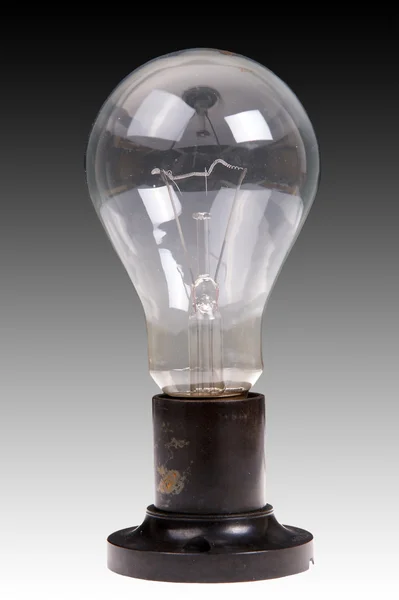 Lámpara incandescente eléctrica cepillada grande, contra un fondo oscuro y blanco —  Fotos de Stock