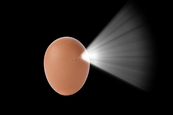 Nuova vita. Un uovo incrinato con luce / energia emergente . — Foto Stock