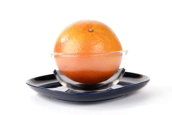 Grapefruit in een glasvaas op een donker blauw bord, witte pagina — Stockfoto