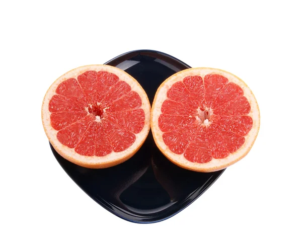Reife rote Grapefruit. die Schnittfrucht auf einem dunkelblauen Teller — Stockfoto
